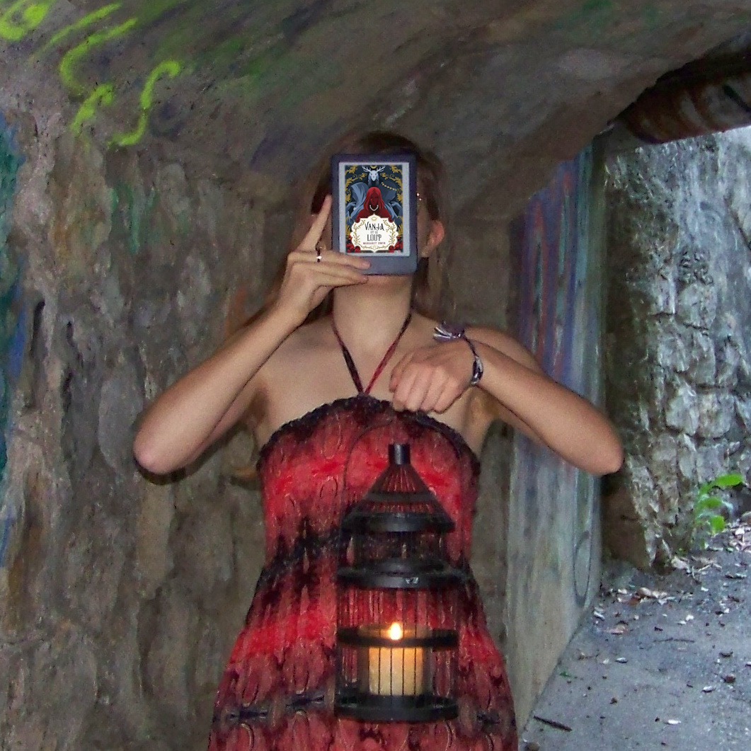 personne en robe noire et rouge lisant Vanja et le Loup de Margaret Owen dans un tunnel avec une lanterne